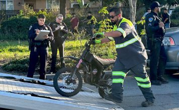 A tow operator lifts one of two electric dirt bikes onto a flatbed truck after being stopped by Watsonville Police