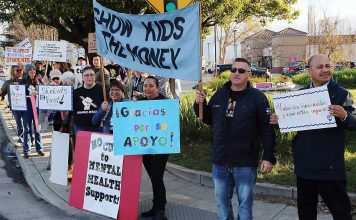 Pajaro Valley Unified School District teachers and staff are joined by community supporters early Tuesday morning at The Towers in Watsonville to rally against teacher layoffs.