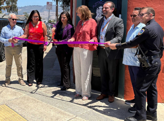 Santa Cruz County District Attorney Jeff Rosell, left, joins Aztecas Youth Soccer Academy founder Gina Castañeda, Chief Probation Officer Sandra Mendez, 1440 Multiversity co-creator Joanie Kriens, Santa Cruz County Superintendent of Schools Faris Sabbah, Ramon Gomez from Santa Cruz County Supervisor Felipe Hernandez’s office and Watsonville Police Chief Brian Shab in a ribbon-cutting ceremony at Aztecas new clubhouse.